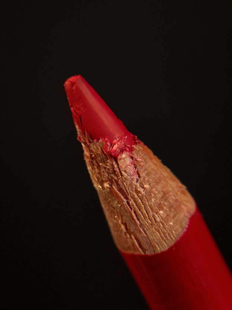 Macro photograph of a sharpened red pencil.
